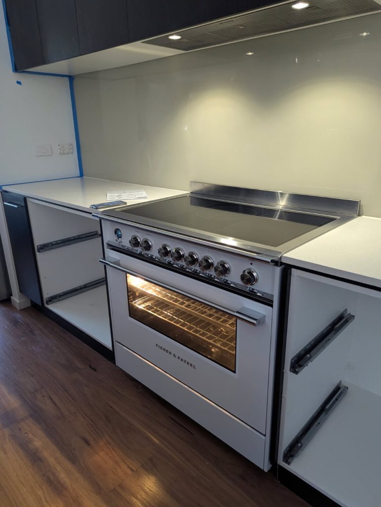 Fisher & Paykel oven with induction cooktop installed in a modern kitchen.