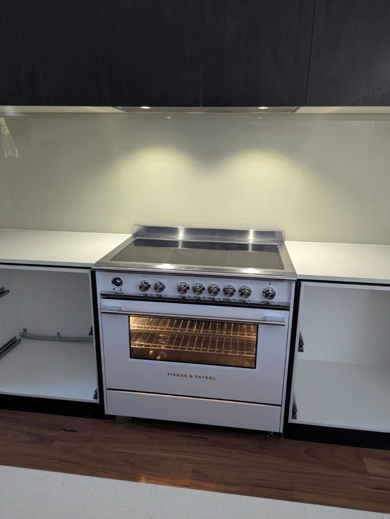 Front view of Fisher & Paykel induction cooktop and oven installed in a new kitchen.
